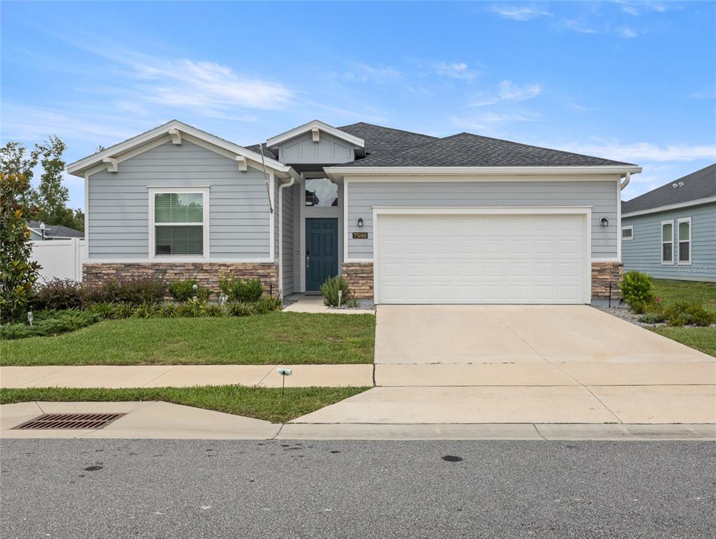 a view of a house with a yard and large tree