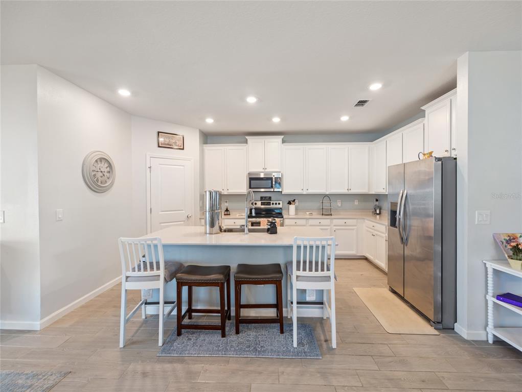 7580 Southwest 78th Terrace Ocala, FL 34481 - Photo 15 of 48 a kitchen with kitchen island a refrigerator and a dining table