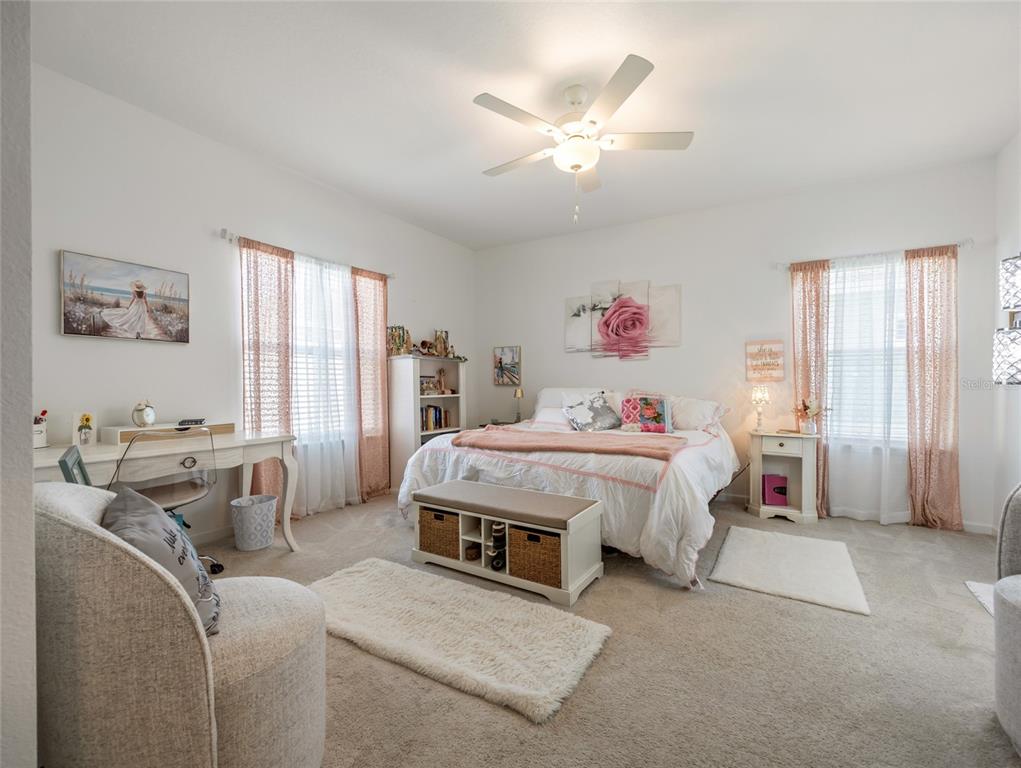 7580 Southwest 78th Terrace Ocala, FL 34481 - Photo 26 of 48 a spacious bedroom with a bed a couch and a window