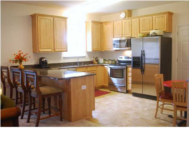 54 Maple Street Santa Rosa Beach, FL 32459 - Photo 2 of 9 a kitchen with stainless steel appliances granite countertop a stove top oven a sink a dining table and chairs