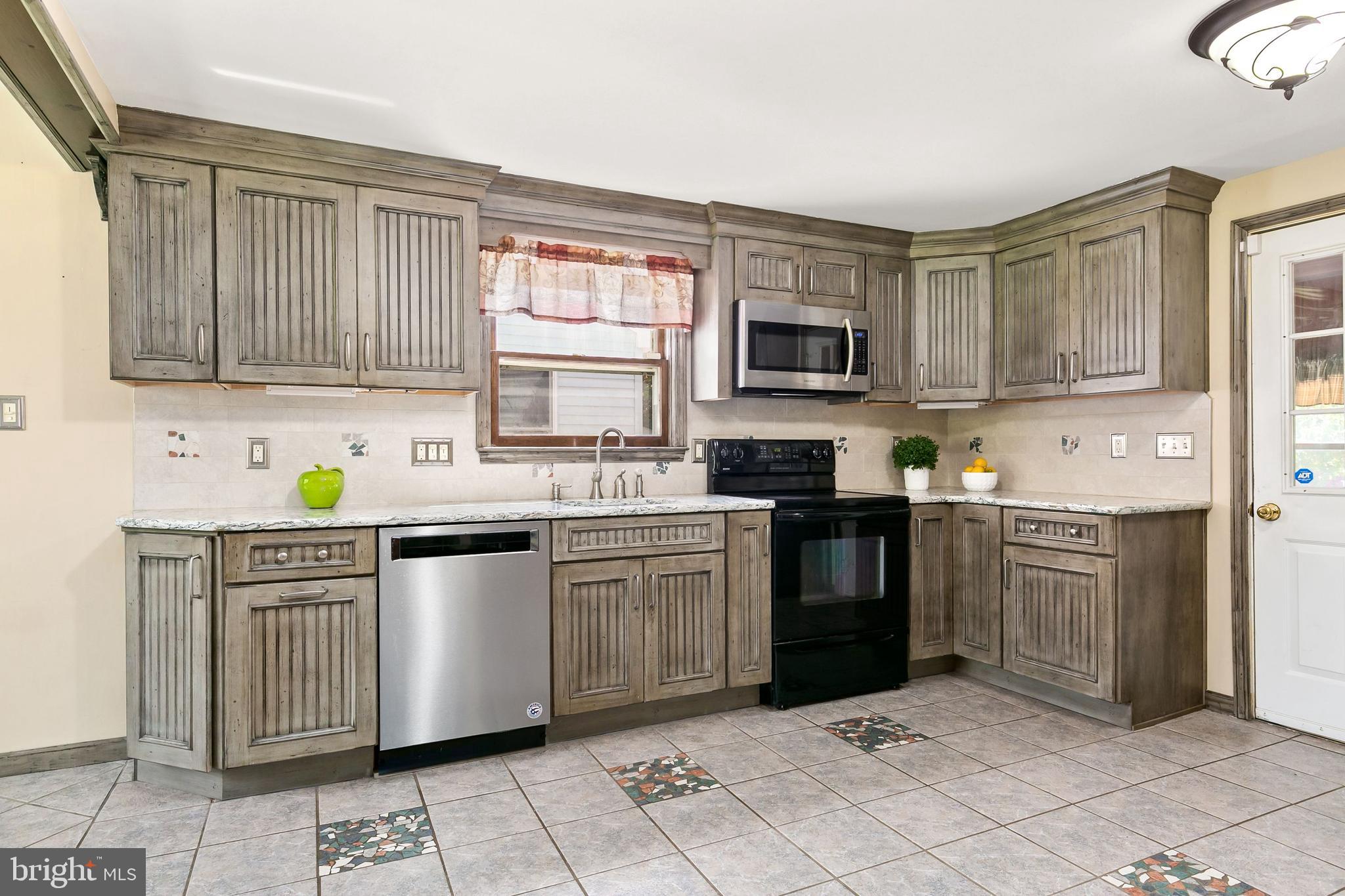 86 Hopkins Road New Egypt, NJ 08533 - Photo 5 of 37 a kitchen with stainless steel appliances granite countertop a stove top oven a sink dishwasher and a refrigerator with wooden cabinets