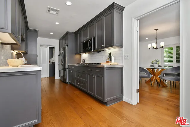 a kitchen with stainless steel appliances granite countertop a refrigerator and a stove top oven