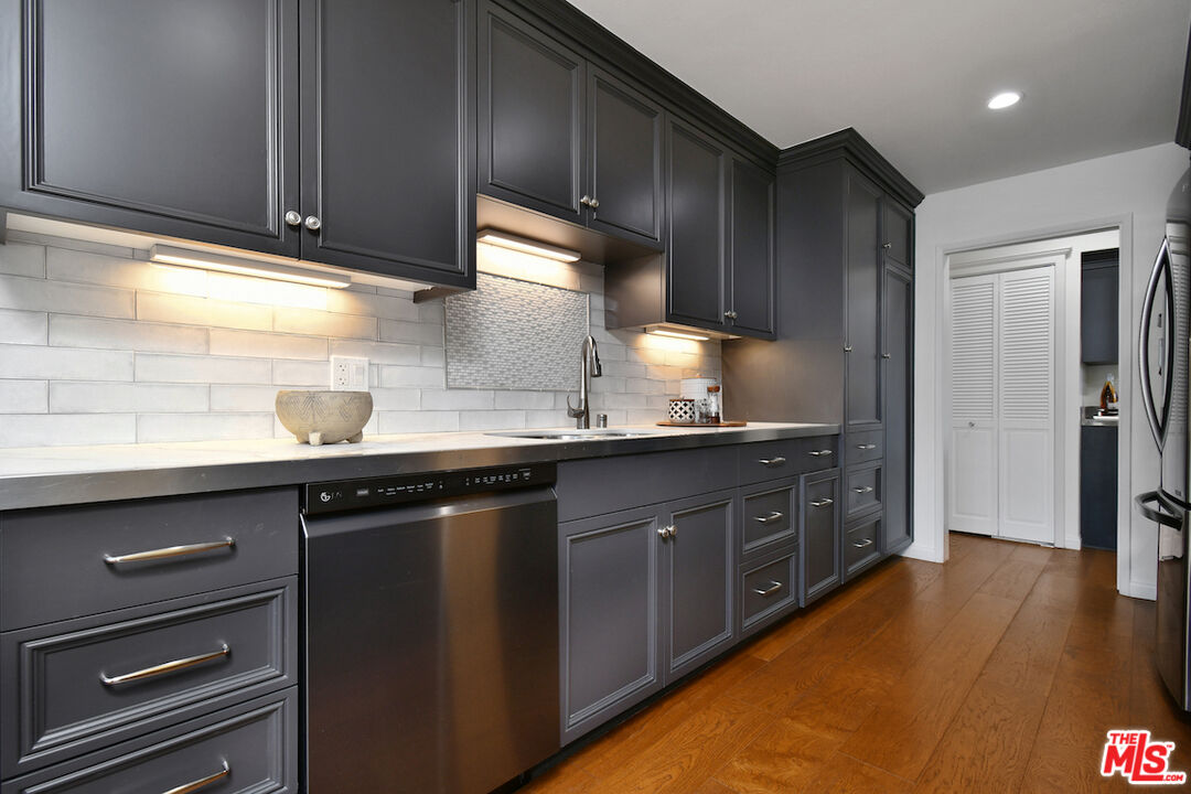 10409 Riverside Drive, Unit 204 Toluca Lake, CA 91602 - Photo 17 of 36 a kitchen with granite countertop a sink cabinets and stainless steel appliances