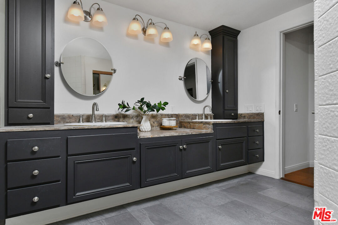 10409 Riverside Drive, Unit 204 Toluca Lake, CA 91602 - Photo 23 of 36 a bathroom with a double vanity sink and a mirror