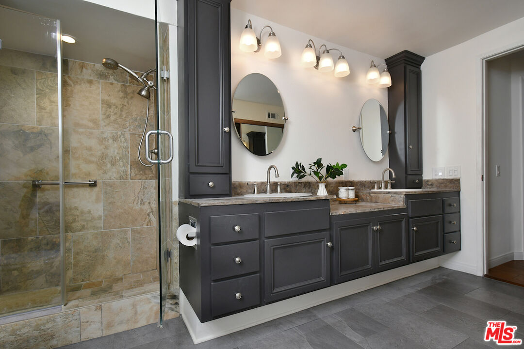 10409 Riverside Drive, Unit 204 Toluca Lake, CA 91602 - Photo 24 of 36 a bathroom with a double vanity sink mirror and shower