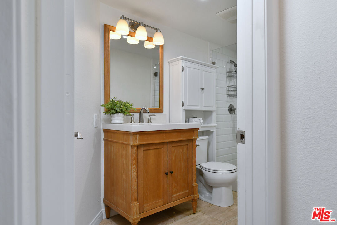 10409 Riverside Drive, Unit 204 Toluca Lake, CA 91602 - Photo 29 of 36 a bathroom with a toilet sink and mirror
