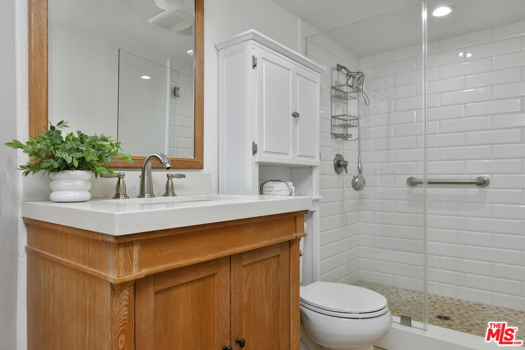 10409 Riverside Drive, Unit 204 Toluca Lake, CA 91602 - Photo 30 of 36 a bathroom with a sink mirror vanity and toilet