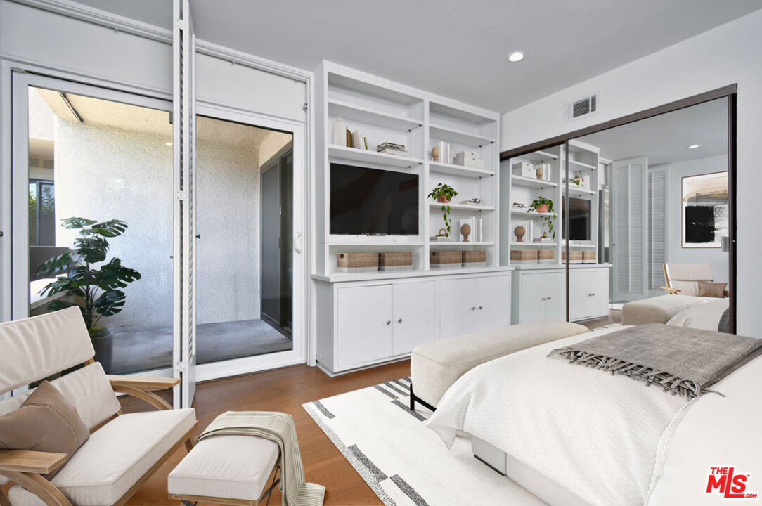 10409 Riverside Drive, Unit 204 Toluca Lake, CA 91602 - Photo 32 of 36 a bedroom with a bed and a flat screen tv