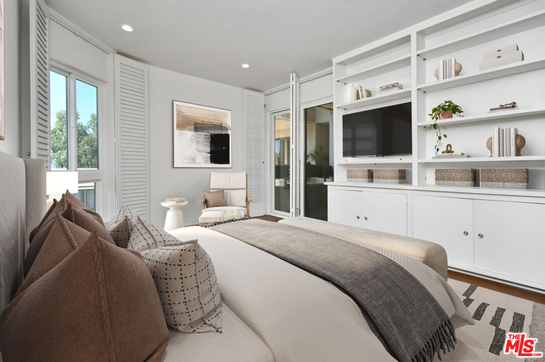 10409 Riverside Drive, Unit 204 Toluca Lake, CA 91602 - Photo 33 of 36 a spacious bedroom with a bed and a flat screen tv