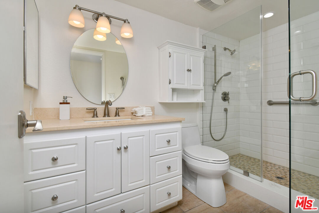 10409 Riverside Drive, Unit 204 Toluca Lake, CA 91602 - Photo 34 of 36 a bathroom with a double vanity sink toilet and shower