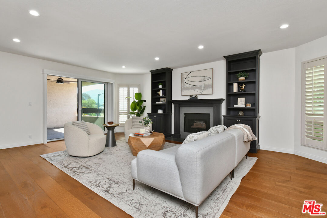 10409 Riverside Drive, Unit 204 Toluca Lake, CA 91602 - Photo 8 of 36 a living room with fireplace furniture and a wooden floor
