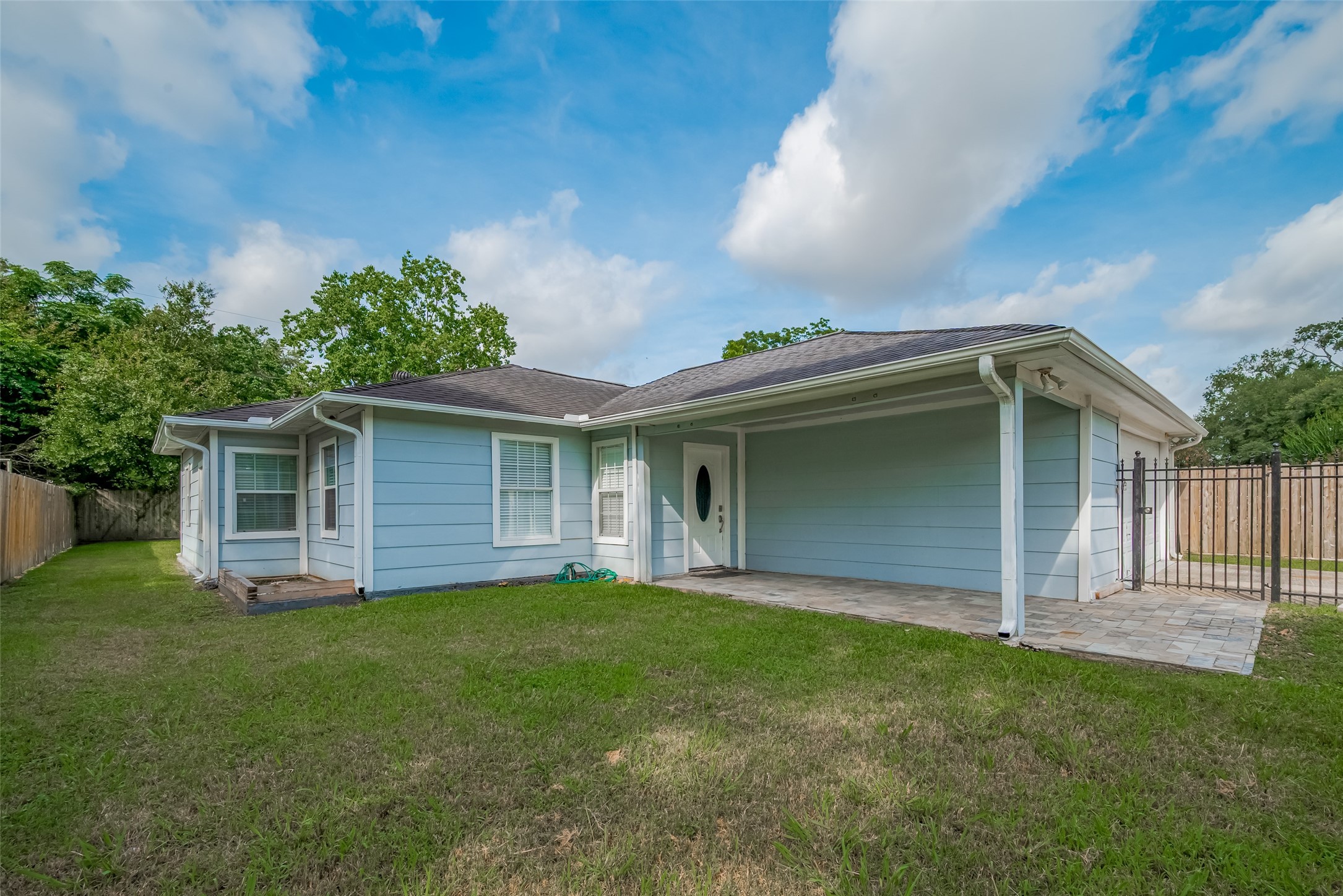 Welcome home! This gated residence pairs a wide driveway with manicured green space and a covered entry that invites you in with understated charm.