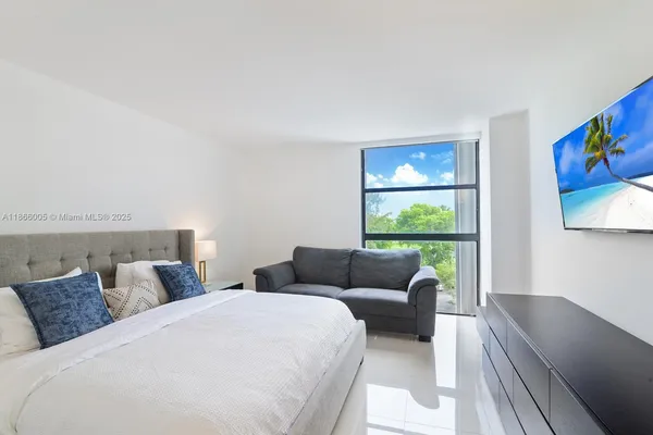 a bedroom with furniture and a large window