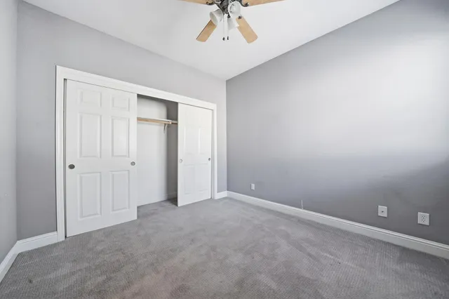 an empty room with a chandelier fan