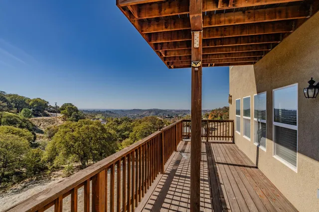 a view of balcony with wooden floor and fence