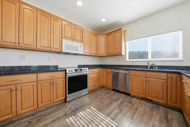 a kitchen with granite countertop stainless steel appliances sink and cabinets