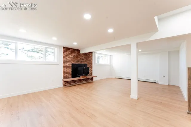 an empty room with wooden floor and stairs