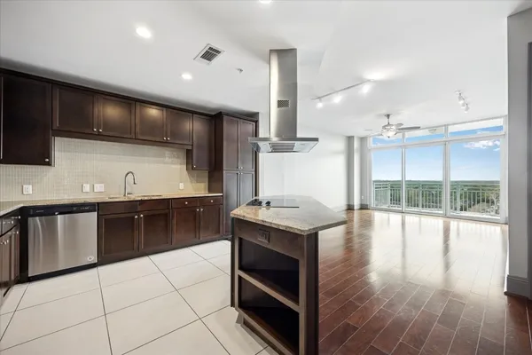 a kitchen with stainless steel appliances kitchen island granite countertop a stove a sink and a microwave