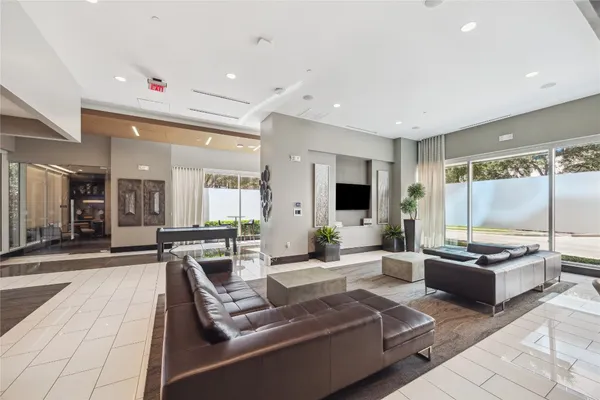 a large living room with stainless steel appliances kitchen island granite countertop a large window and couch