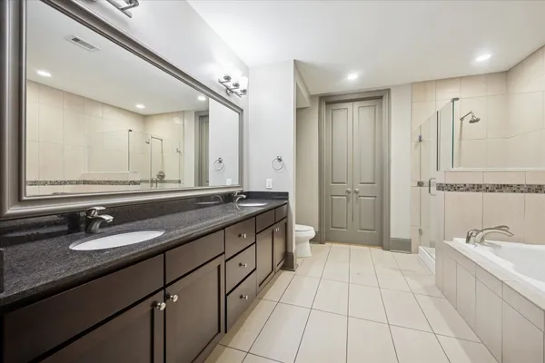 a spacious bathroom with a double vanity sink a mirror and a bathtub