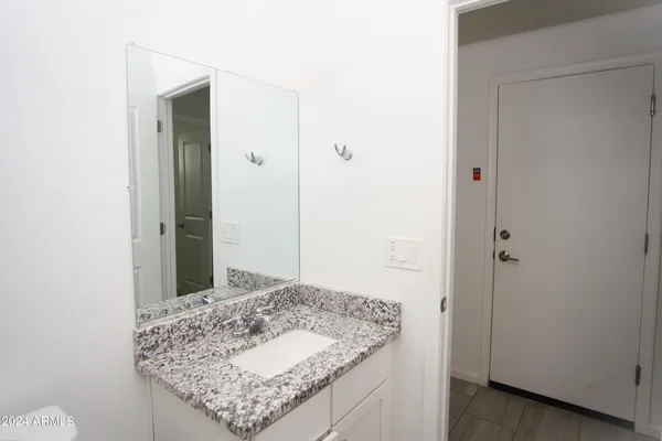 a bathroom with a granite countertop sink and a mirror
