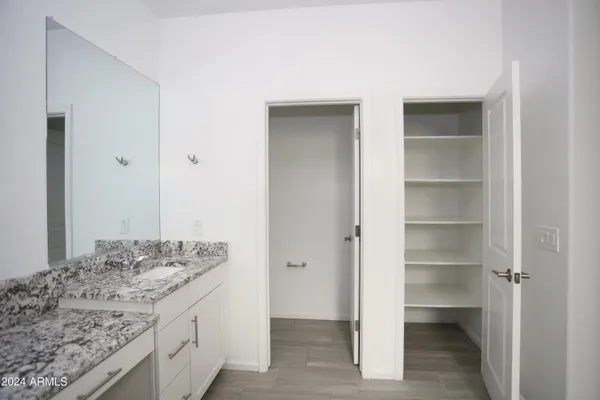 a bathroom with a granite countertop sink and a mirror