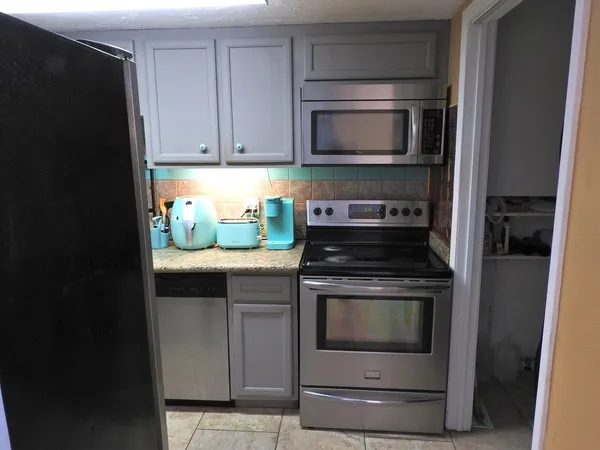 a kitchen with granite countertop a stove and a microwave