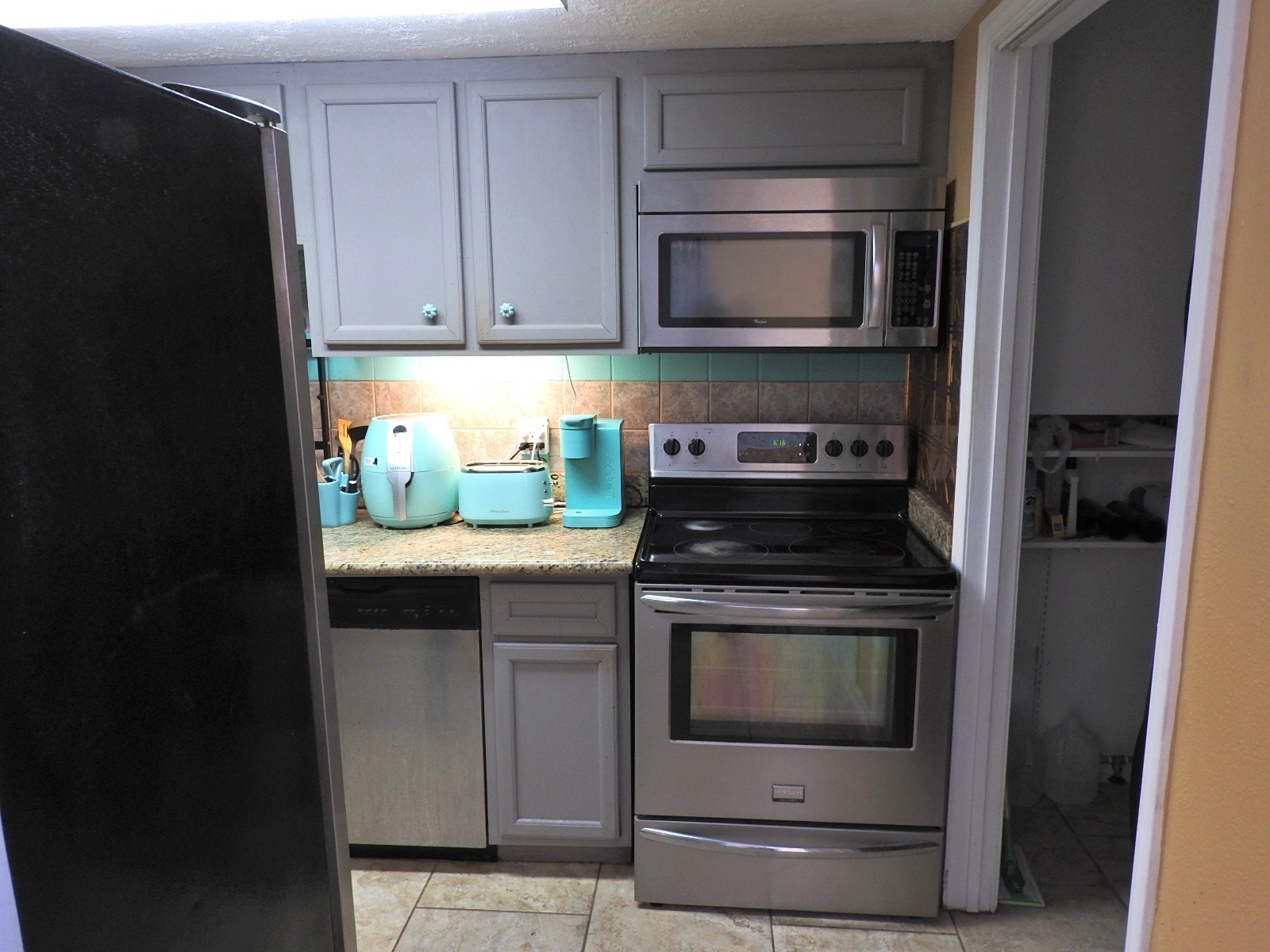 7047 Bissonnet Street, Unit 44 Houston, TX 77074 - Photo 3 of 20 a kitchen with granite countertop a stove and a microwave