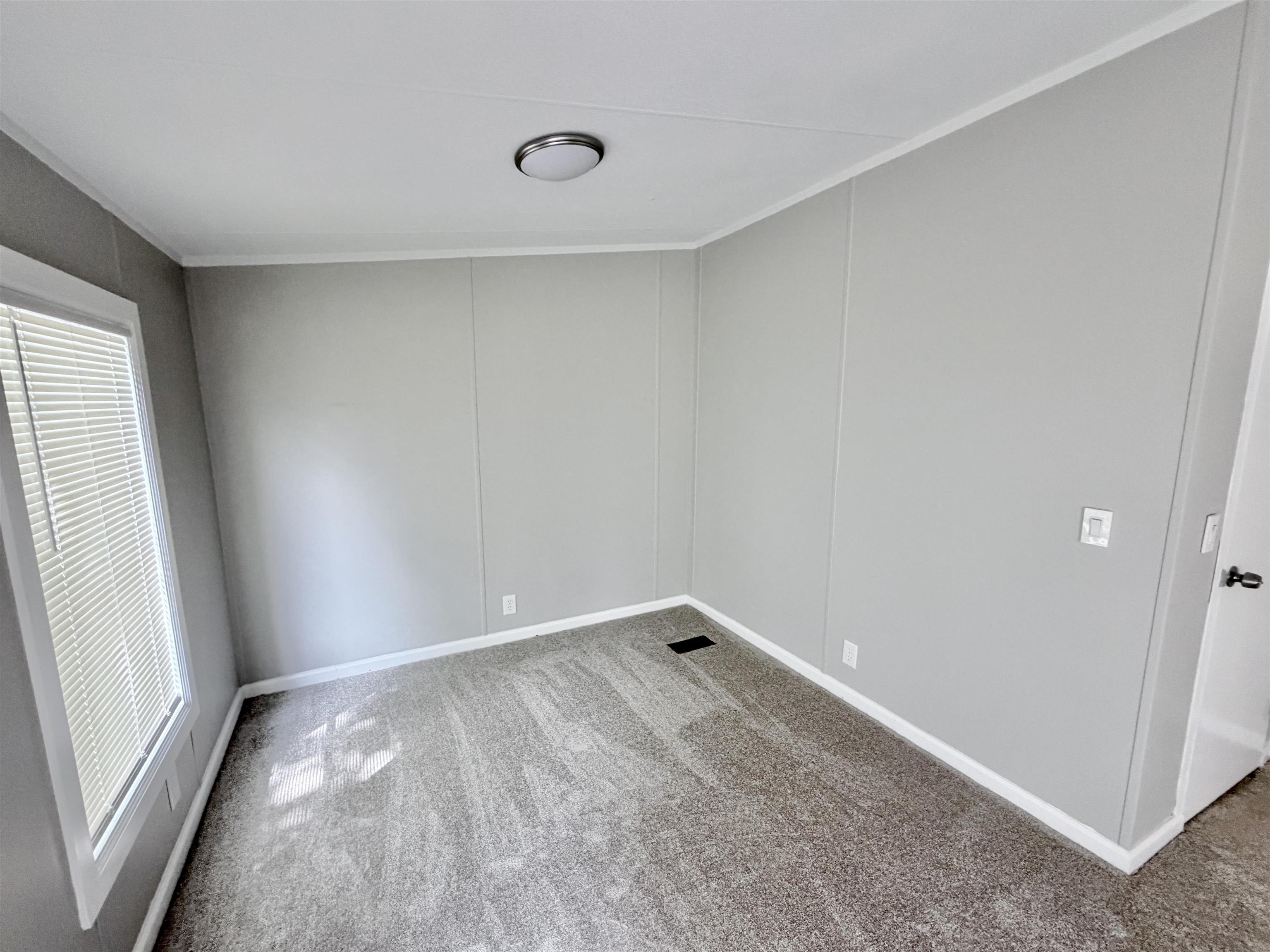 1655 Fayne Road Brighton, TN 38011 - Photo 16 of 28 Interior room featuring wall-to-wall carpeting, light gray wall panels, white trim, and a window with blinds