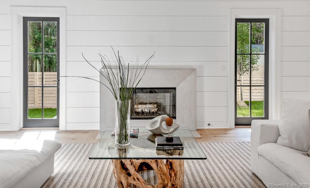 1 Deerfield Road Darien, CT 06820 - Photo 12 of 40 a living room with furniture a fireplace and a floor to ceiling window