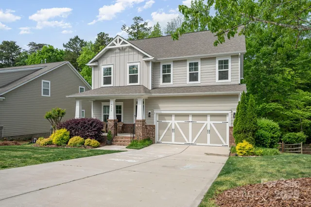a front view of a house with a yard and potted plants