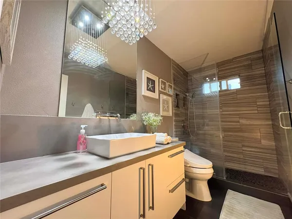 a bathroom with a granite countertop sink a toilet and shower