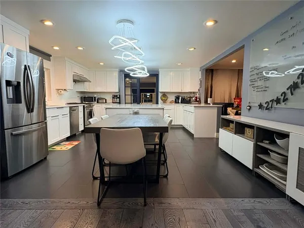 an open kitchen with kitchen island wooden cabinets and stainless steel appliances