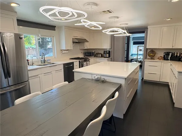 a kitchen with kitchen island a stove and a refrigerator