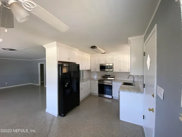 a kitchen with stainless steel appliances a stove sink and refrigerator