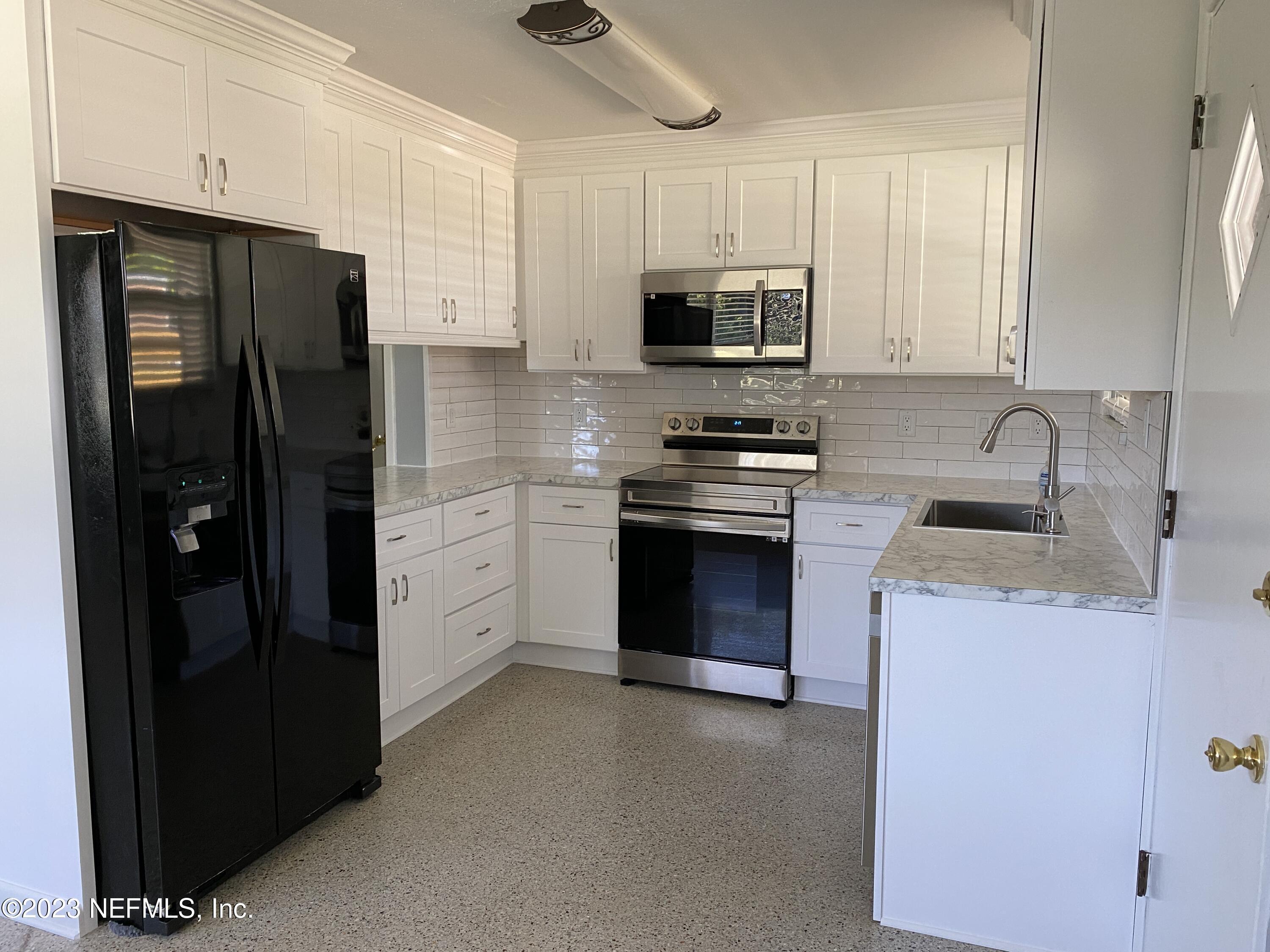 102 St Elmo Road Green Cove Springs, FL 32043 - Photo 15 of 15 a kitchen with stainless steel appliances a stove sink and refrigerator