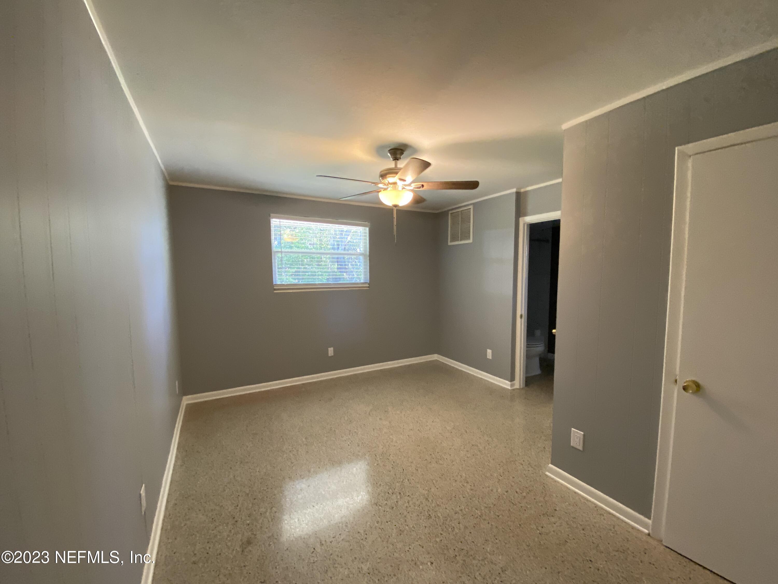 102 St Elmo Road Green Cove Springs, FL 32043 - Photo 6 of 15 an empty room with windows and chandelier fan
