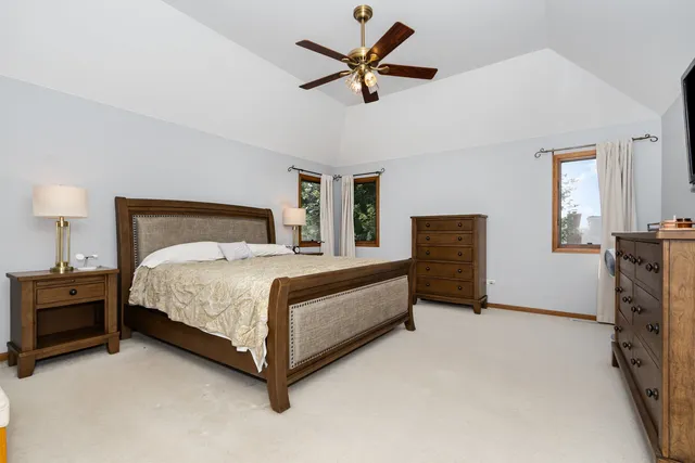 a bedroom with a bed a chandelier and a dresser