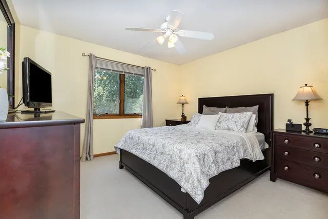 a bedroom with a bed and a flat tv screen on dresser