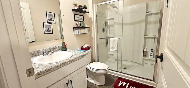 a bathroom with a sink a toilet and shower
