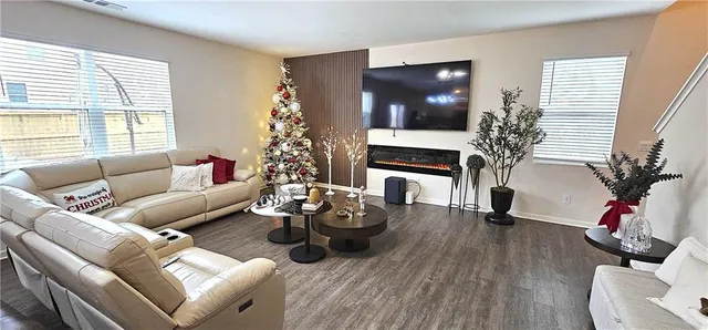 a living room with furniture a flat screen tv and a fireplace