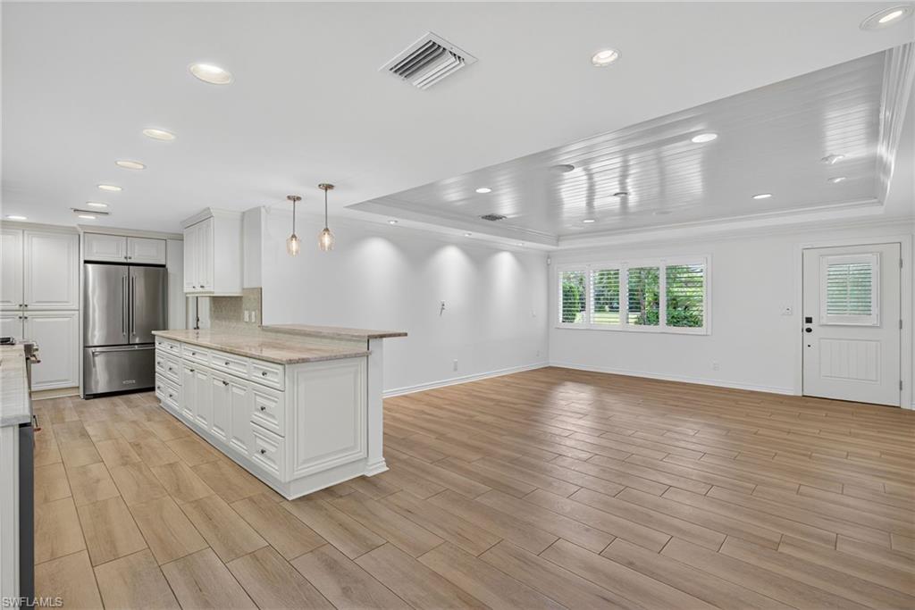 1135 7th Street South Naples, FL 34102 - Photo 13 of 35 an empty room with wooden floor and windows