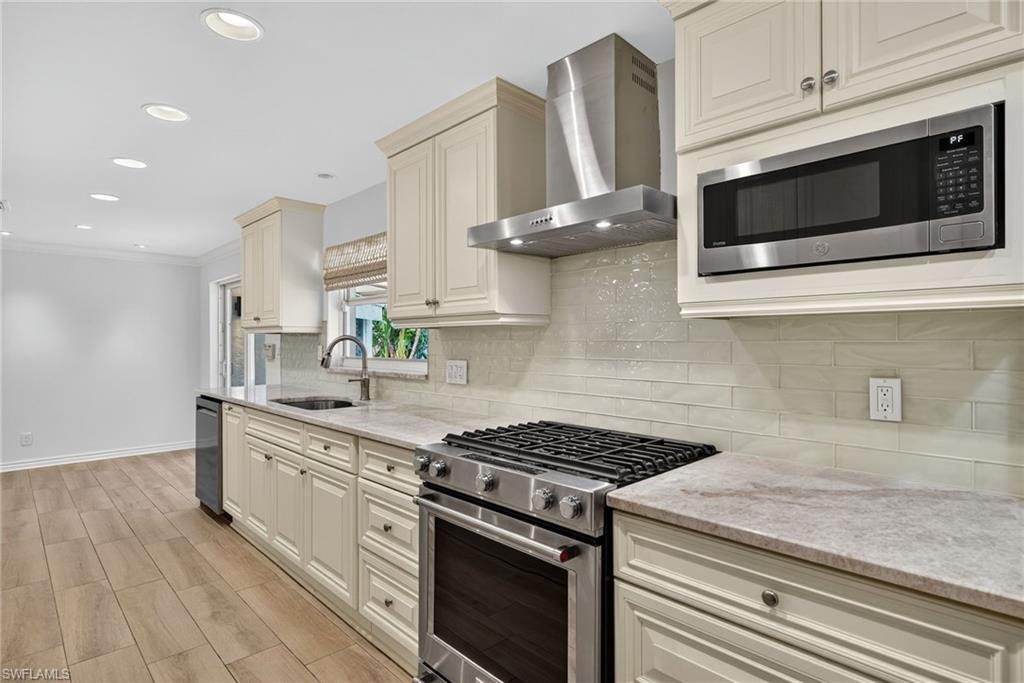 1135 7th Street South Naples, FL 34102 - Photo 15 of 35 a kitchen with stainless steel appliances a sink a stove and microwave