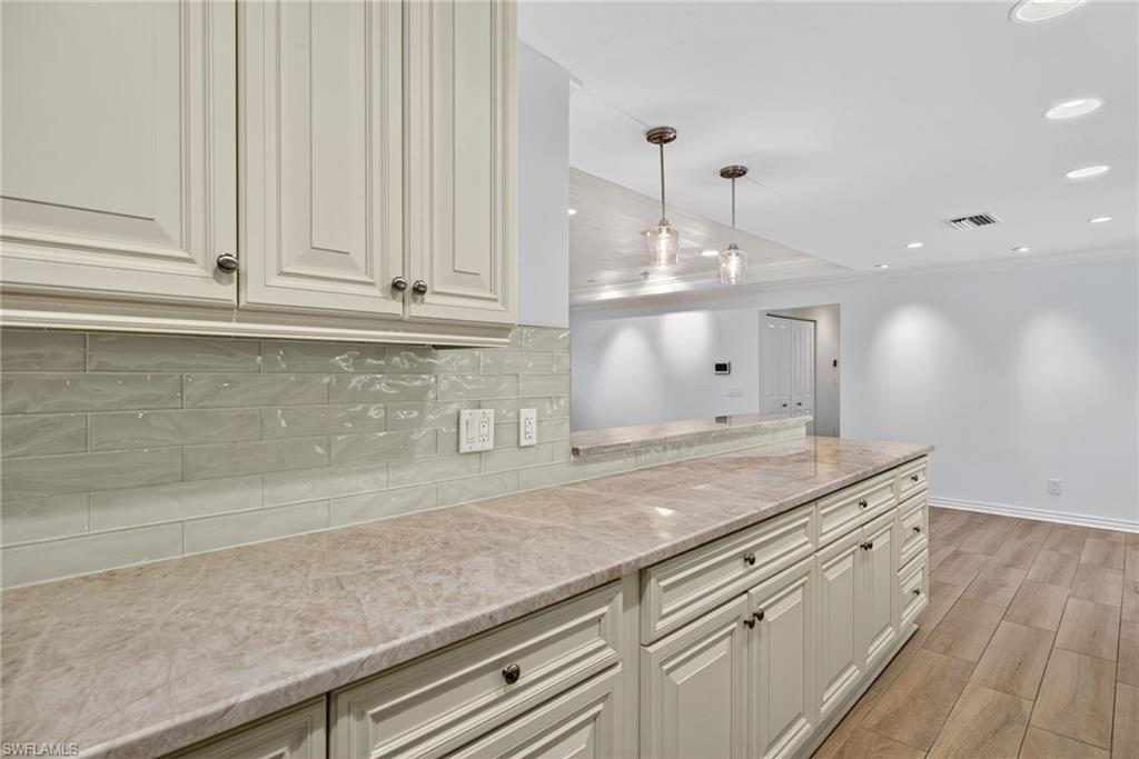 1135 7th Street South Naples, FL 34102 - Photo 16 of 35 a kitchen with granite countertop white cabinets and white appliances