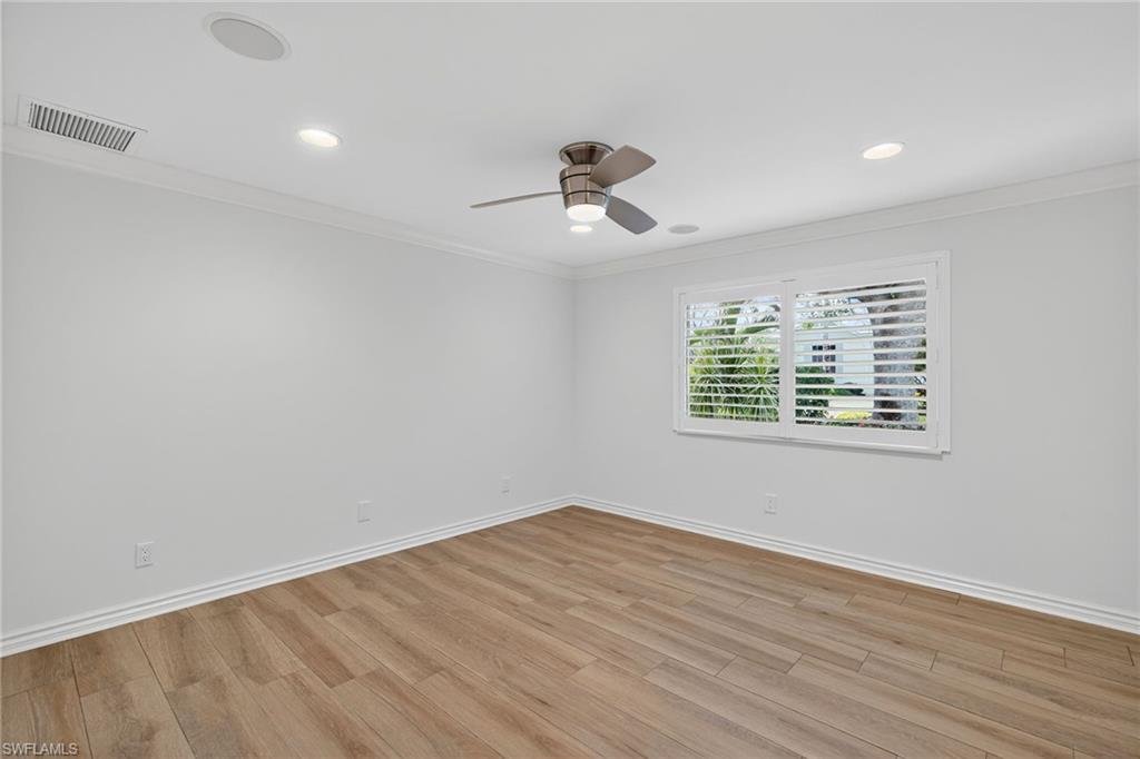1135 7th Street South Naples, FL 34102 - Photo 24 of 35 wooden floor in an empty room with a window