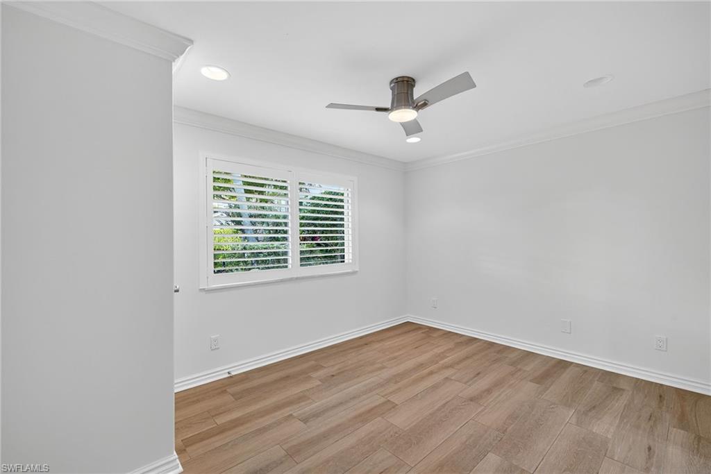 1135 7th Street South Naples, FL 34102 - Photo 26 of 35 wooden floor in an empty room with a window