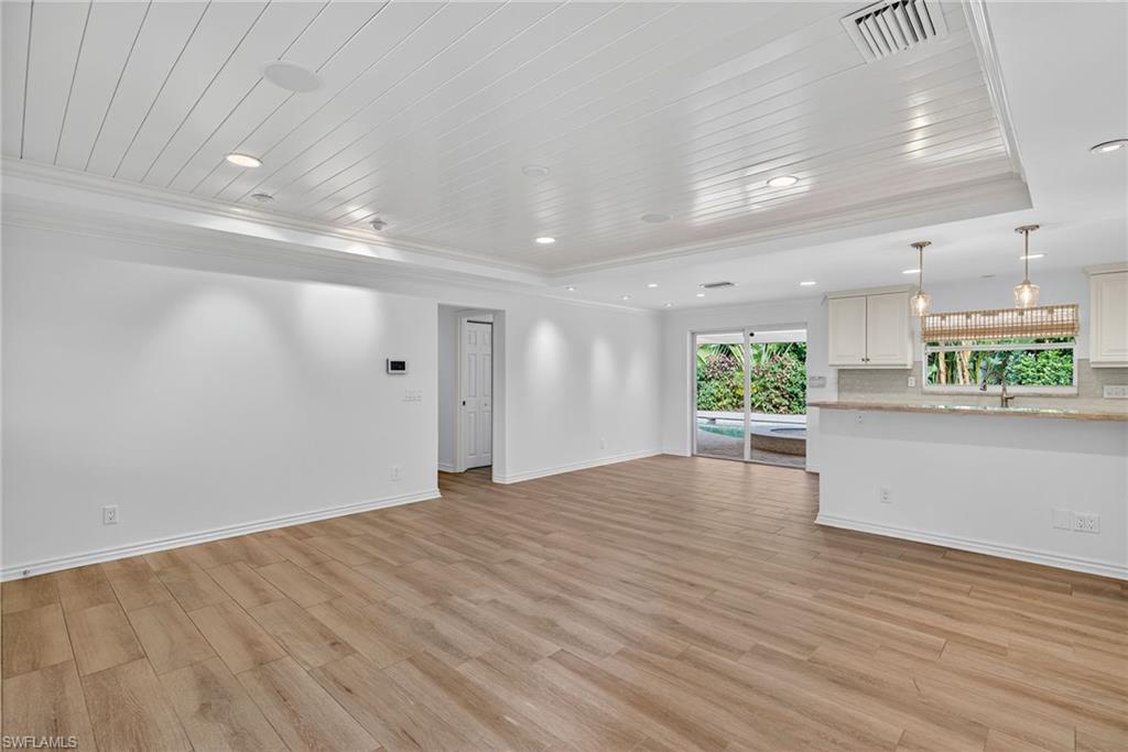 1135 7th Street South Naples, FL 34102 - Photo 9 of 35 an empty room with wooden floor and windows