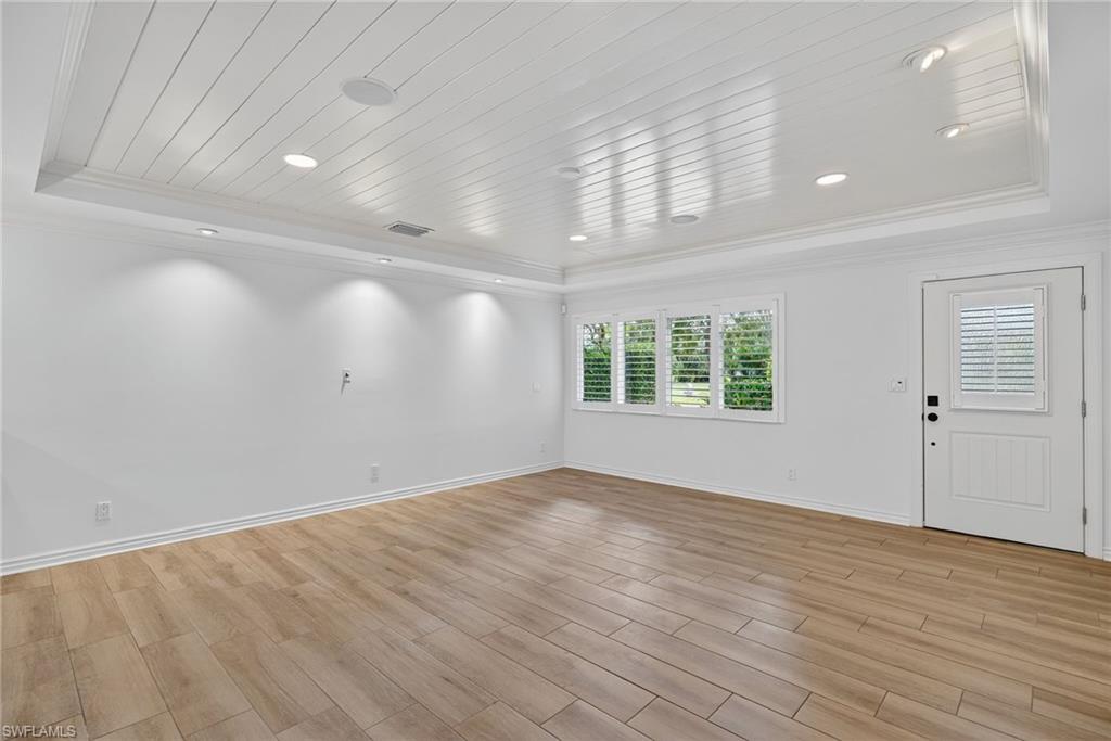 1135 7th Street South Naples, FL 34102 - Photo 10 of 35 an empty room with wooden floor and windows