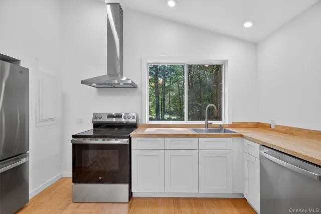 a kitchen with granite countertop a sink stainless steel appliances and cabinets