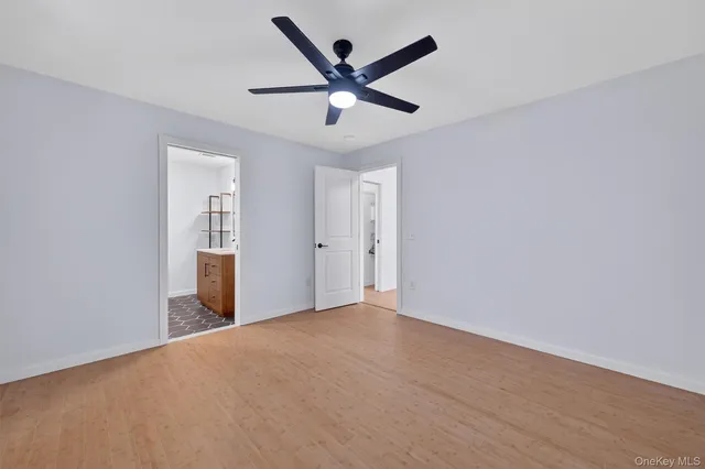 an empty room with closet and ceiling fan